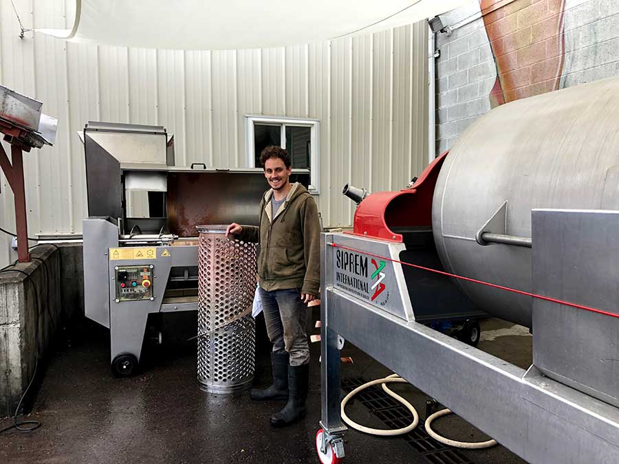 Wes Andrew, harvest intern, near the wine press