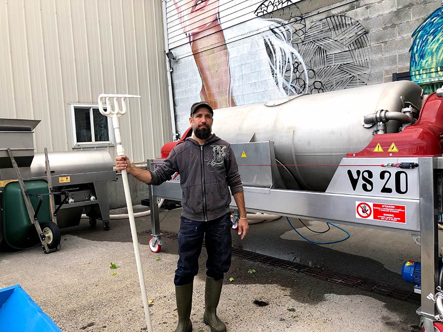 George Nosis, winemaker, next to winemaking equipment