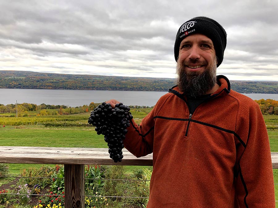 Winemaker George Nosis, holding a cluster of grapes in the vineyard